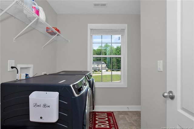 laundry room with independent washer and dryer and baseboards