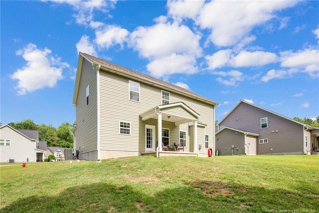 back of house featuring a patio area and a lawn