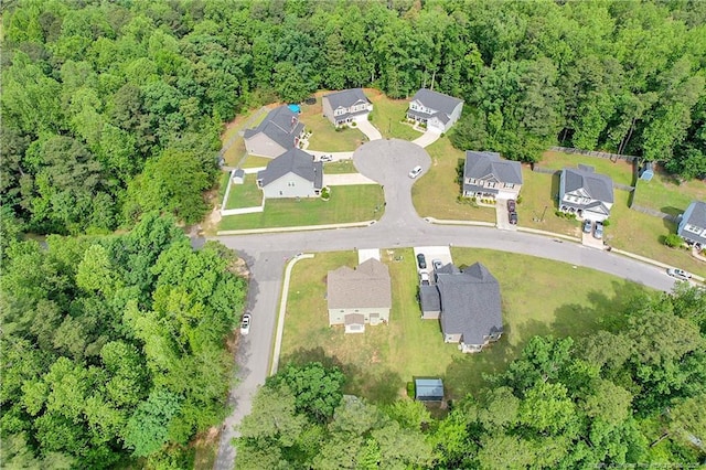 view of property location featuring a heavily wooded area and nearby suburban area