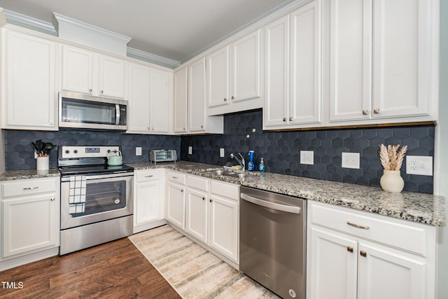 187 Ashley Woods Ct, Clayton, NC 27527 - kitchen featuring stainless steel appliances, wood finished floors, white cabinets, decorative backsplash, and ornamental molding