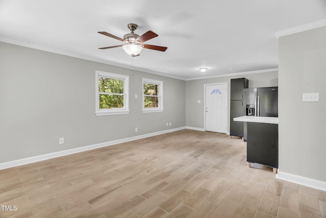 308 Lynn Rd, Durham, NC 27703 - unfurnished living room with a ceiling fan, baseboards, light wood finished floors, and crown molding
