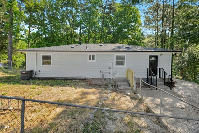 308 Lynn Rd, Durham, NC 27703 - back of house featuring central air condition unit, a fenced backyard, and view of wooded area