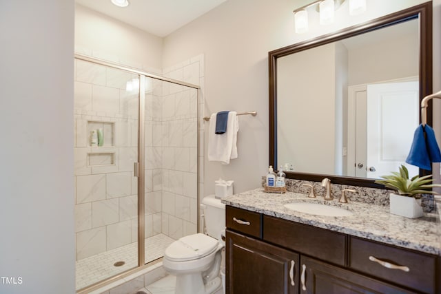 bathroom featuring toilet, a stall shower, and vanity