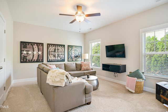 carpeted living area featuring a ceiling fan and baseboards