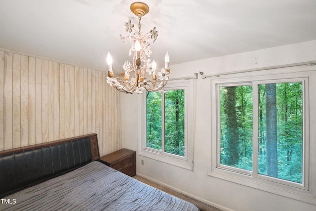 3416 Ocotea St, Raleigh, NC 27607 - bedroom featuring a chandelier, multiple windows, baseboards, and wood walls