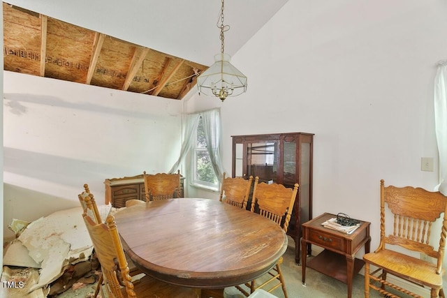 dining room featuring high vaulted ceiling and a chandelier