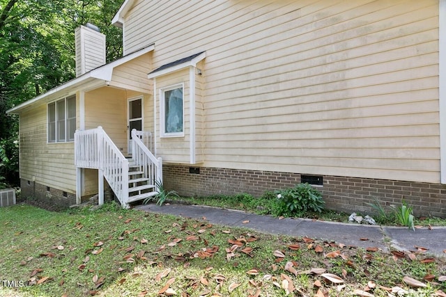 view of side of property featuring crawl space and a chimney