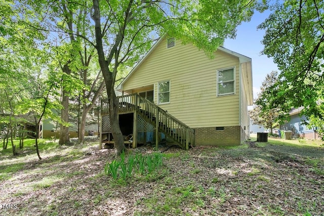 rear view of property with stairway, crawl space, and central AC