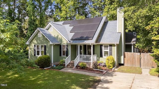 909 Alderleaf Dr, Fuquay Varina, NC 27526 - view of front of home with a porch, solar panels, a chimney, and roof with shingles
