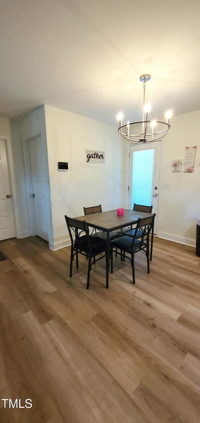 212 Placid Pond Dr, Broadway, NC 27505 - dining room featuring a chandelier, light wood-style floors, and baseboards