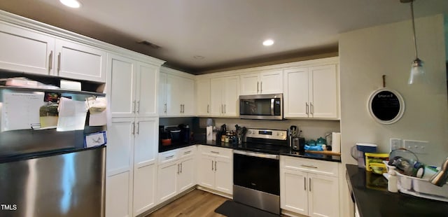 212 Placid Pond Dr, Broadway, NC 27505 - kitchen with stainless steel appliances, dark countertops, white cabinetry, wood finished floors, and recessed lighting