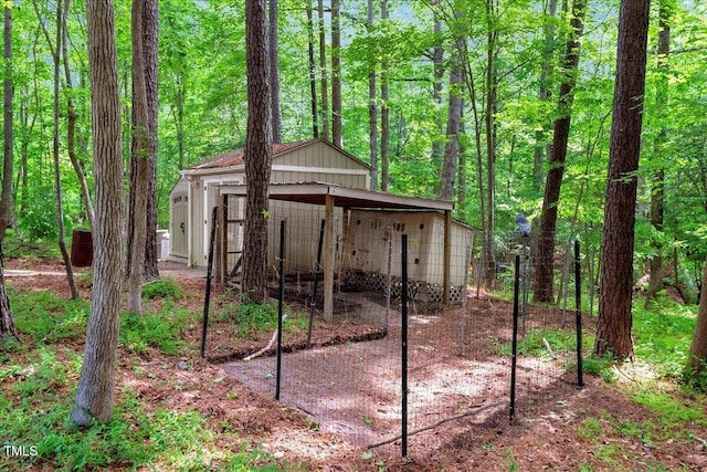 view of outbuilding with an outbuilding and a forest view