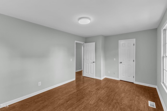 unfurnished bedroom with wood finished floors and baseboards