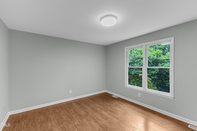 spare room with wood finished floors and baseboards
