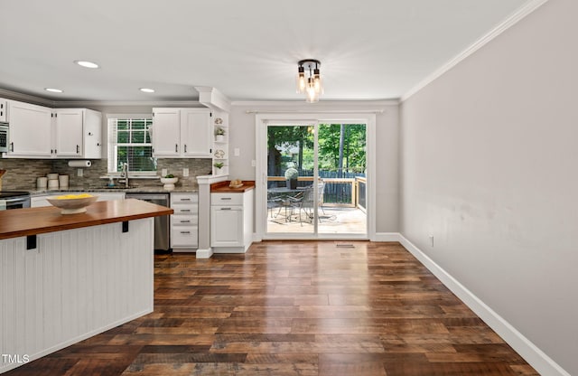 kitchen with butcher block counters, dishwasher, crown molding, decorative backsplash, and plenty of natural light
