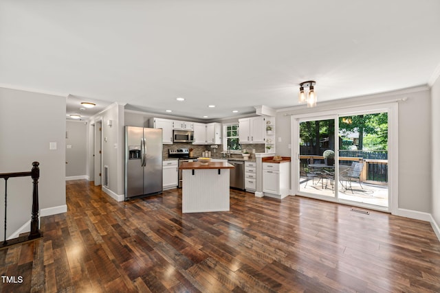 kitchen featuring stainless steel appliances, wood counters, crown molding, decorative backsplash, and dark wood finished floors