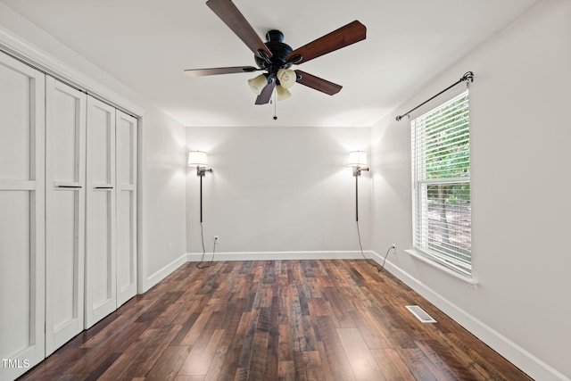 unfurnished bedroom featuring dark wood-type flooring, baseboards, and ceiling fan