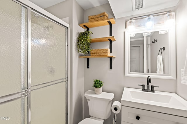 bathroom with a shower stall, toilet, and vanity