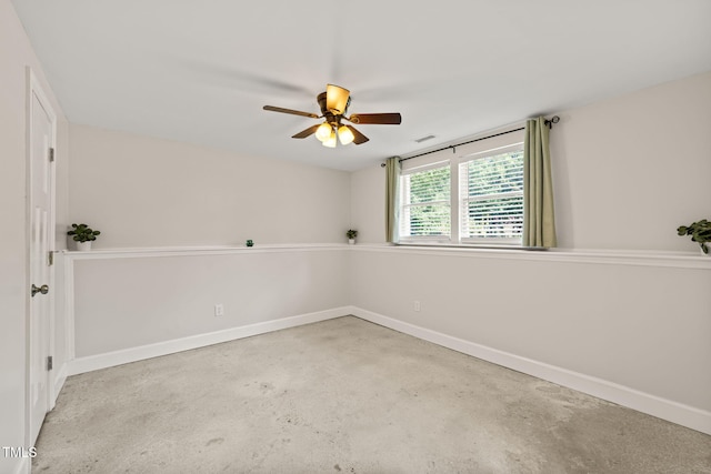 empty room with a ceiling fan, baseboards, and unfinished concrete flooring