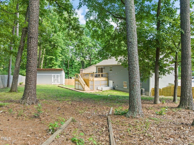 view of yard with a wooden deck, stairs, an outbuilding, and a storage unit