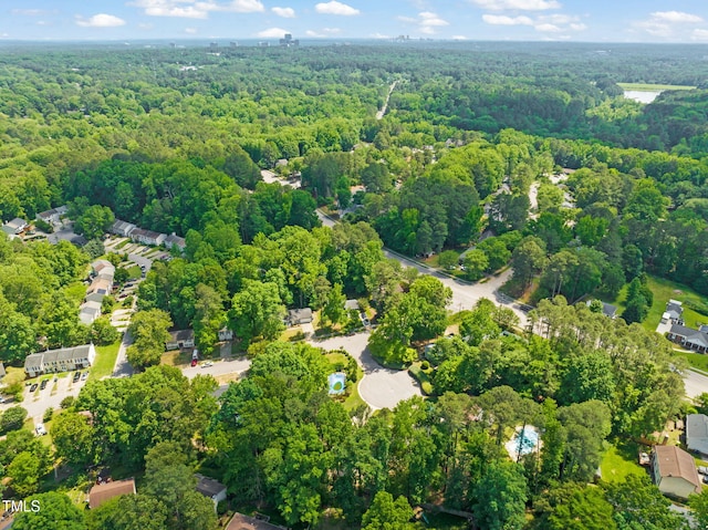 aerial view of property and surrounding area featuring a heavily wooded area