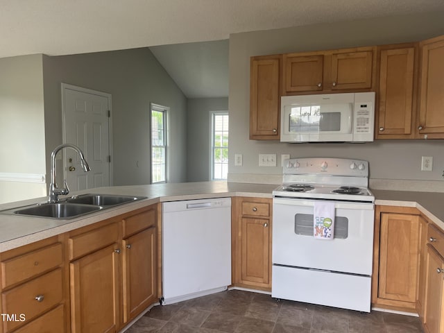 kitchen with white appliances, a sink, vaulted ceiling, light countertops, and brown cabinets