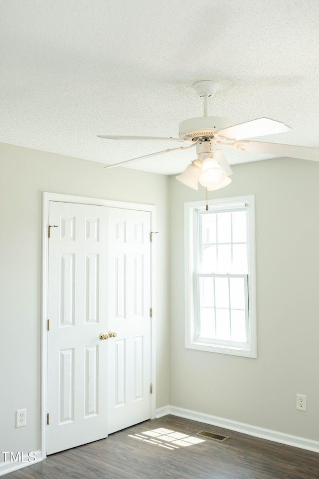 12 Linsey Ct, Lillington, NC 27546 - unfurnished bedroom with dark wood-style floors, baseboards, ceiling fan, a closet, and a textured ceiling