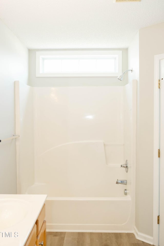12 Linsey Ct, Lillington, NC 27546 - bathroom featuring washtub / shower combination, vanity, healthy amount of natural light, and wood finished floors
