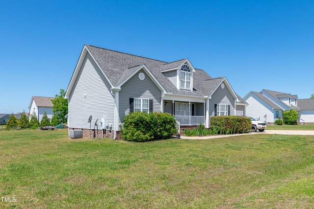 view of front of property featuring a front yard, roof with shingles, covered porch, and central AC unit