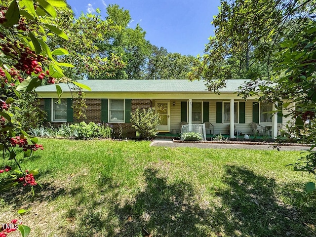 single story home with covered porch, a front lawn, and brick siding