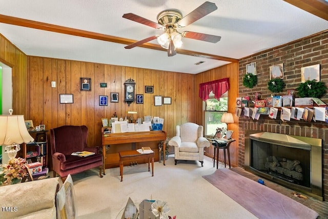 living area featuring a brick fireplace, ceiling fan, wood walls, and carpet floors