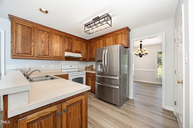 kitchen featuring stainless steel refrigerator with ice dispenser, white range with electric cooktop, under cabinet range hood, a sink, and light countertops