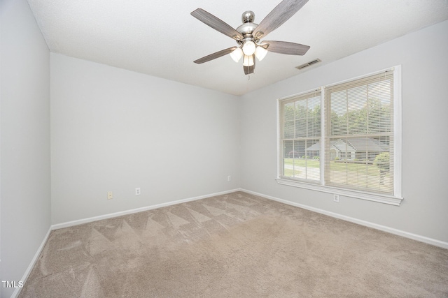 empty room with baseboards, light colored carpet, and ceiling fan