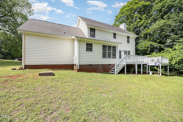 rear view of house with a deck, stairs, a chimney, a lawn, and crawl space