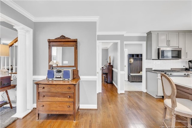 1110 Oakridge Blvd, Lumberton, NC 28358 - kitchen with stainless steel microwave, gray cabinets, decorative columns, light wood-style floors, and crown molding