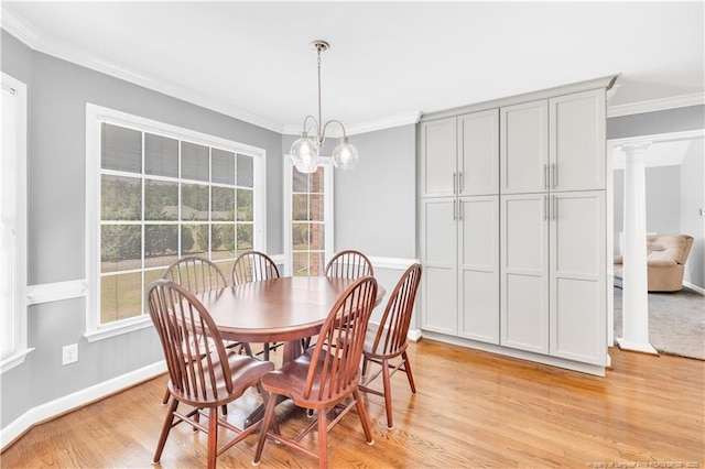 1110 Oakridge Blvd, Lumberton, NC 28358 - dining area featuring ornamental molding, light wood finished floors, baseboards, ornate columns, and a chandelier