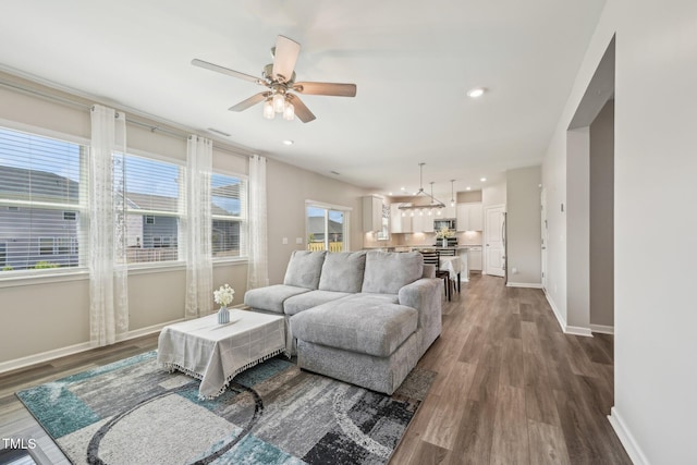 living room with dark wood-style floors, a ceiling fan, baseboards, and recessed lighting