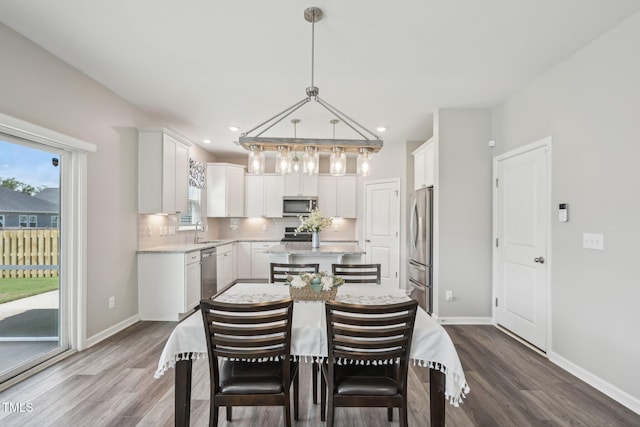 dining room with dark wood-style flooring, baseboards, and recessed lighting