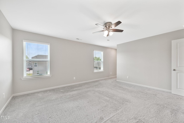 empty room featuring ceiling fan, baseboards, and carpet