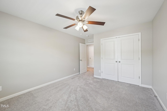 unfurnished bedroom with carpet flooring, baseboards, and a closet