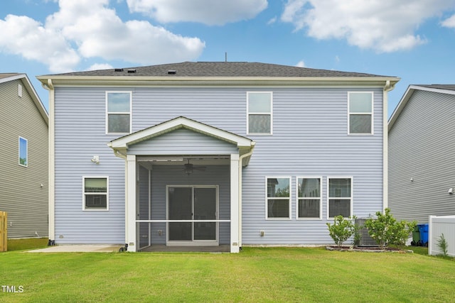 rear view of property featuring ceiling fan, a lawn, and a sunroom