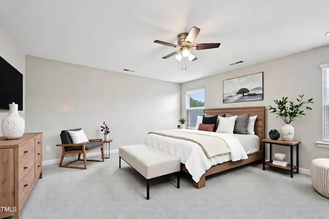 bedroom featuring light colored carpet, baseboards, and a ceiling fan