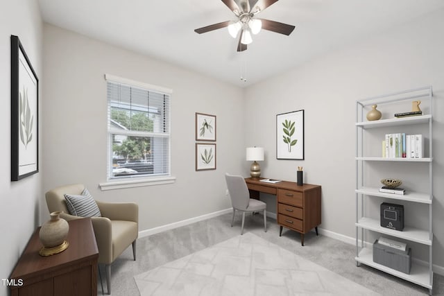 home office with light carpet, a ceiling fan, and baseboards