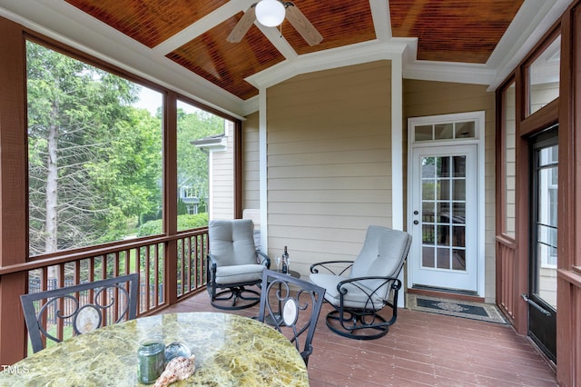 sunroom with lofted ceiling, a ceiling fan, healthy amount of natural light, and outdoor dining space