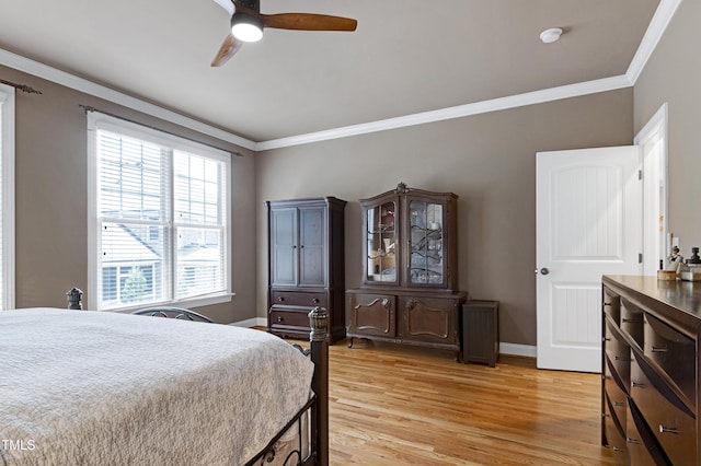 bedroom featuring crown molding, light wood finished floors, baseboards, and a ceiling fan