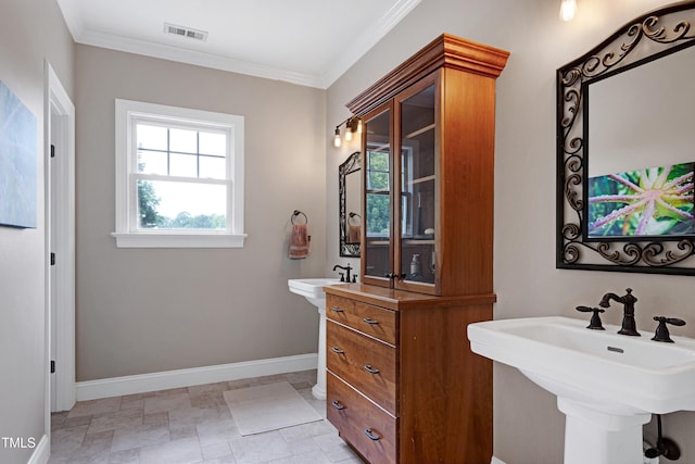 bathroom featuring baseboards, ornamental molding, a sink, and stone finish flooring