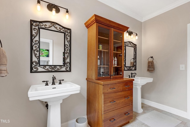 bathroom with ornamental molding, two sinks, baseboards, and tile patterned floors
