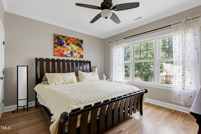 bedroom with baseboards, ornamental molding, wood finished floors, and ceiling fan