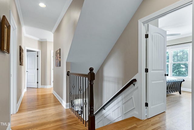 hallway with light wood finished floors, an upstairs landing, ornamental molding, recessed lighting, and baseboards