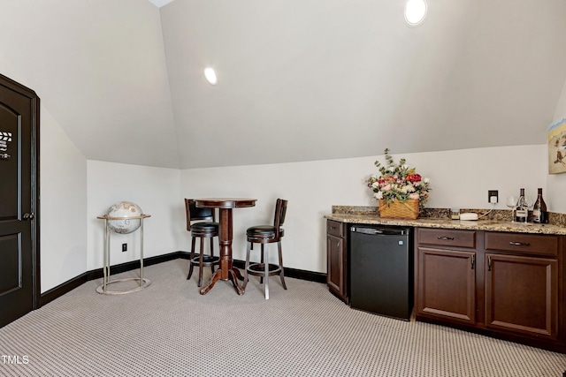 indoor dry bar with fridge, light carpet, lofted ceiling, and baseboards